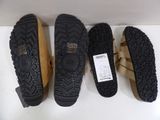 three pairs of clogs are lined up on a shelf