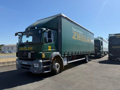 un camion vert qui roule dans la rue