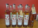 six bouteilles de jus de baies sont alignées sur une table