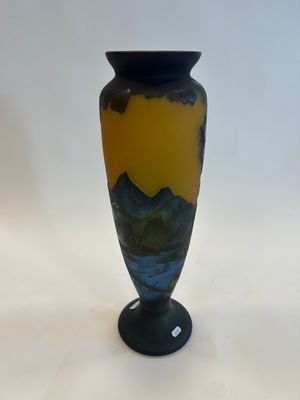 a blue and yellow vase sitting on a white surface