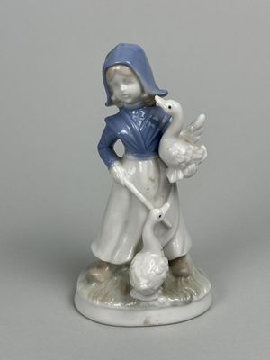une figurine représentant une petite fille tenant un canard et une oie