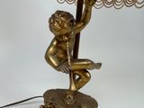 a small statue of a boy holding a lamp