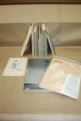 de nombreux livres posés sur une table, avec beaucoup de papiers