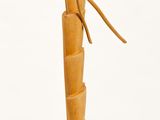 wooden sculpture of a bird on a branch on a white surface