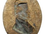 a close up of a bronze medallion with a woman ' s face on it