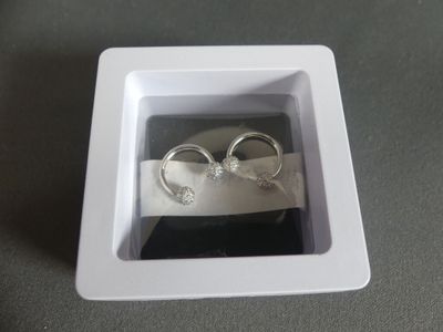 two wedding rings in a white box on a table