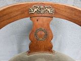 a wooden chair with a metal ring on the back