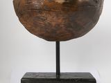 an old wooden bowl sitting on top of a black stand