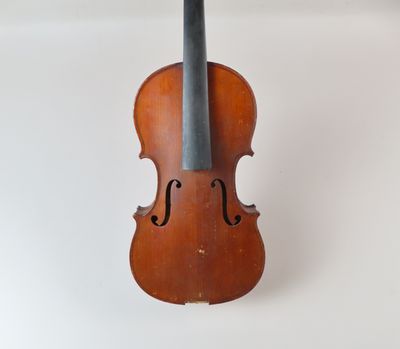 un vieux violon posé sur une surface blanche