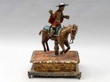 une figurine représentant un homme à cheval, posée sur une boîte