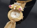 an image of a close up of a wrist watch with a tassel