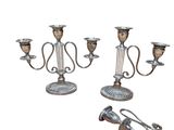 two silver candlesticks and a pair of scissors on a white background