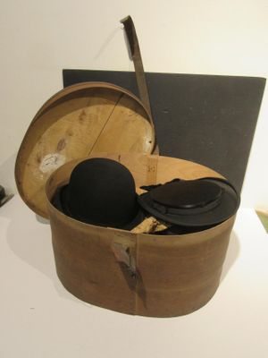 une boîte en bois contenant un chapeau, posée sur une table