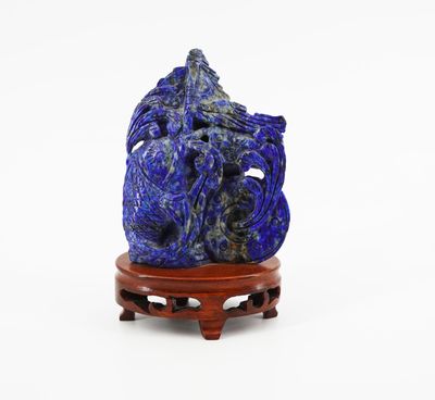 a close up of a blue stone sculpture on a wooden stand