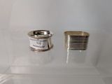 a silver ring and a silver cup on a glass shelf