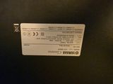 a label on the back of a black refrigerator