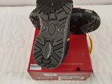 the sole of a pair of black hiking shoes on top of a red box