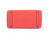 a red leather wallet with a metal frame on a white background