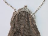 a silver mesh purse with a chain strap and a clasp