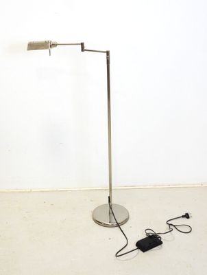 le lampadaire se trouve à côté d'un chargeur posé par terre