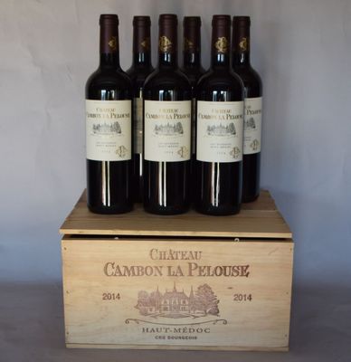 quatre bouteilles de vin rouge dans un coffret en bois posé sur une table