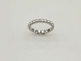 une bague ornée de perles argentées sur un fond blanc
