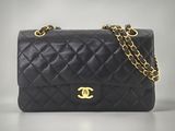 un sac Chanel noir muni d'une bandoulière en chaîne dorée