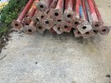 a pile of pipes sitting on the sidewalk next to a fence