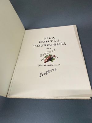 un livre ouvert posé sur une table à côté d'une tasse de café