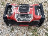 a red and black lawn mower sitting on the ground