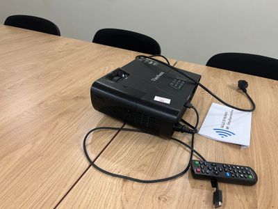 un petit projecteur posé sur une table, avec une télécommande