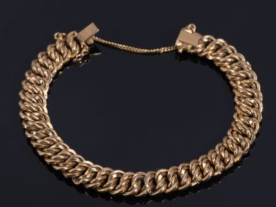 a gold chain bracelet on a black surface