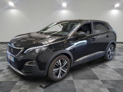 Une voiture noire est garée dans une pièce au sol carrelé en damier.