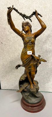 statue en bronze représentant une femme tenant un oiseau et un oiseau perché sur une branche