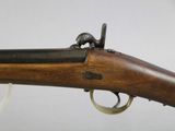 a close up of a rifle with a wooden barrel and brass fittings