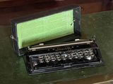 an old typewriter sitting on top of a green table