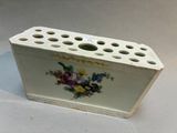un vase blanc sur lequel est peint un bouquet de fleurs