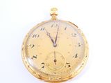 a gold pocket watch with roman numerals on the face