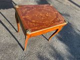 a small wooden table with a floral design on it