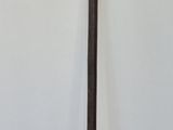 a tall wooden pole with a metal handle in a room