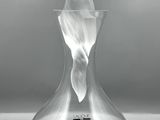 un vase en verre contenant une statuette, posé sur une table