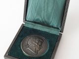 an image of a silver medal in a box on a white surface