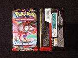 two packs of pokemon cards sitting on top of a black surface