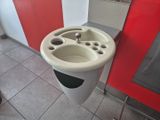 un lavabo dans des toilettes publiques, avec un mur rouge et blanc