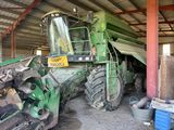 a green tractor that is parked inside of a building