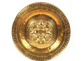 une assiette en or ornée d'un motif sur un fond blanc