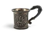 une vieille coupe en argent munie d'une anse et ornée d'un motif
