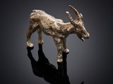 an image of a goat figurine on a reflective surface