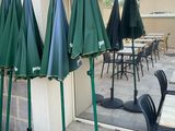 Plusieurs parapluies verts sont alignés à l'extérieur d'un immeuble