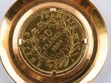 a gold plate with a coin in the middle of it